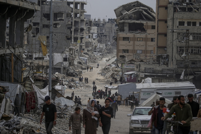 Internally displaced Palestinians move in the streets of Al Shejaeya neighbouhood in the east of Gaza City